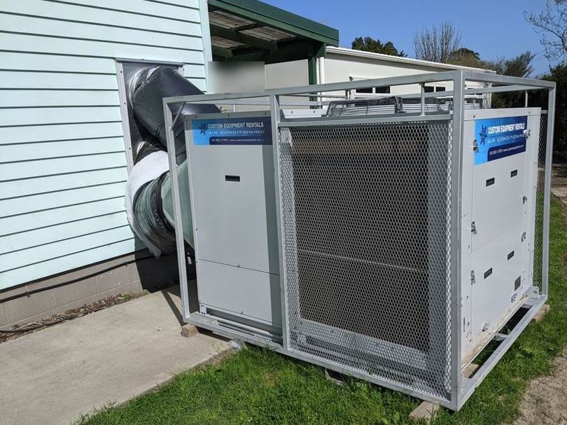 A caged 44 kW unit on site, ducted into the wall of a building